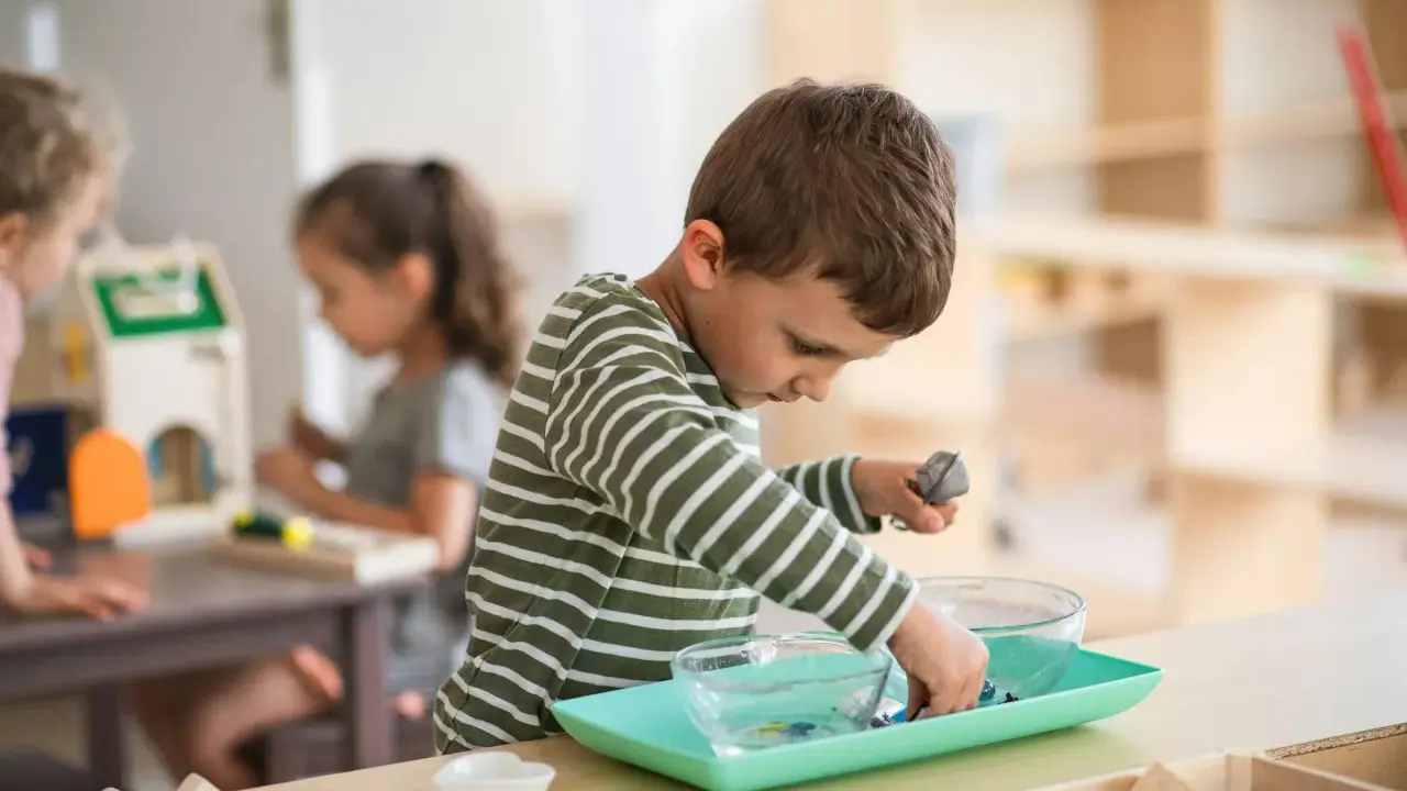 Niño concentrado en actividad de trasvase en un aula Montessori España.