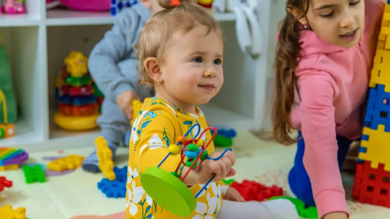 Niños jugando con bloques y juguetes, fomentando el desarrollo del niño de 0 a 6 años.