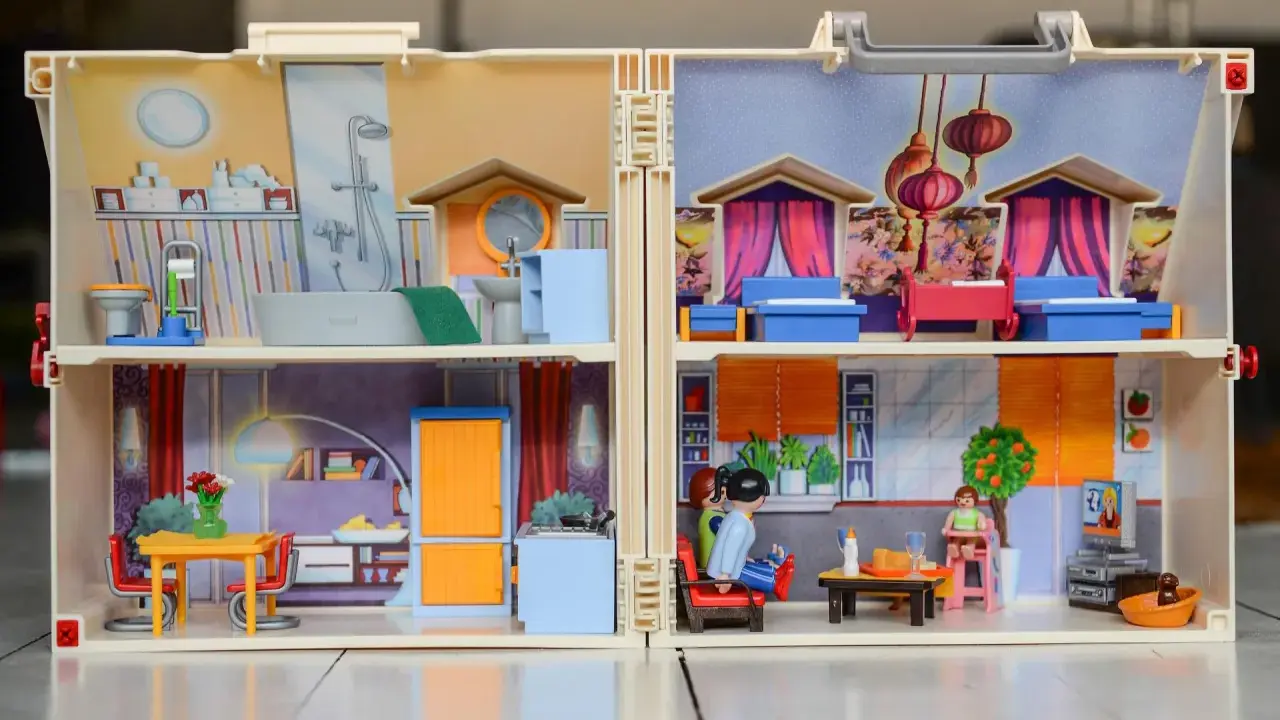 Casa de muñecas con habitaciones detalladas, mostrando actividades de la vida diaria ejemplos como baño, cocina y sala.