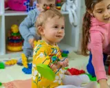 Niños jugando con bloques y juguetes, fomentando el desarrollo del niño de 0 a 6 años.