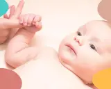 Bebé de 2 meses con ojos curiosos, agarrando un dedo. Una imagen tierna para la rutina de sueño bebe 2 meses.