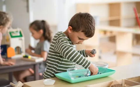 Niño concentrado en actividad de trasvase en un aula Montessori España.