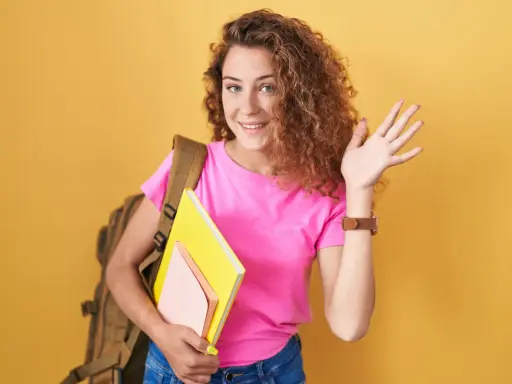 Chica sonriente con mochila y libros, lista para el colegio. ¡Bienvenida!