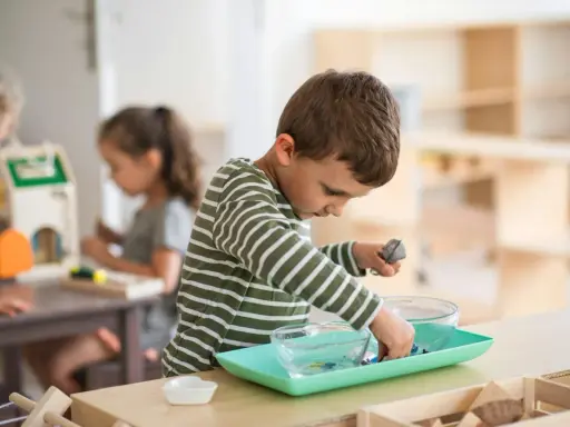 Niño concentrado en actividad de trasvase en un aula Montessori España.