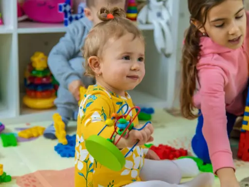 Niños jugando con bloques y juguetes, fomentando el desarrollo del niño de 0 a 6 años.