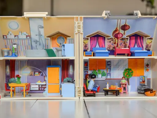 Casa de muñecas con habitaciones detalladas, mostrando actividades de la vida diaria ejemplos como baño, cocina y sala.