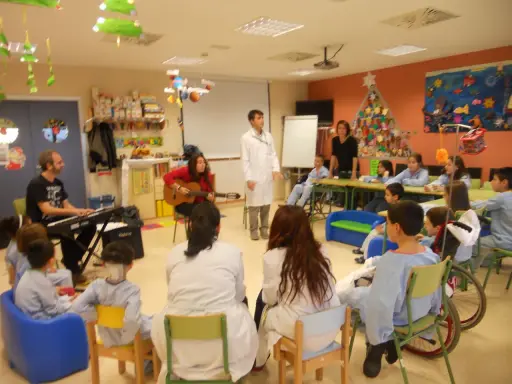 Niños y adultos participan en estaciones de aprendizaje, con música y actividades creativas.