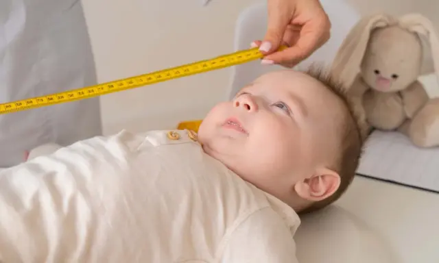 Bebé siendo medido con cinta métrica. El peso de un niño de 2 años es importante para su desarrollo.