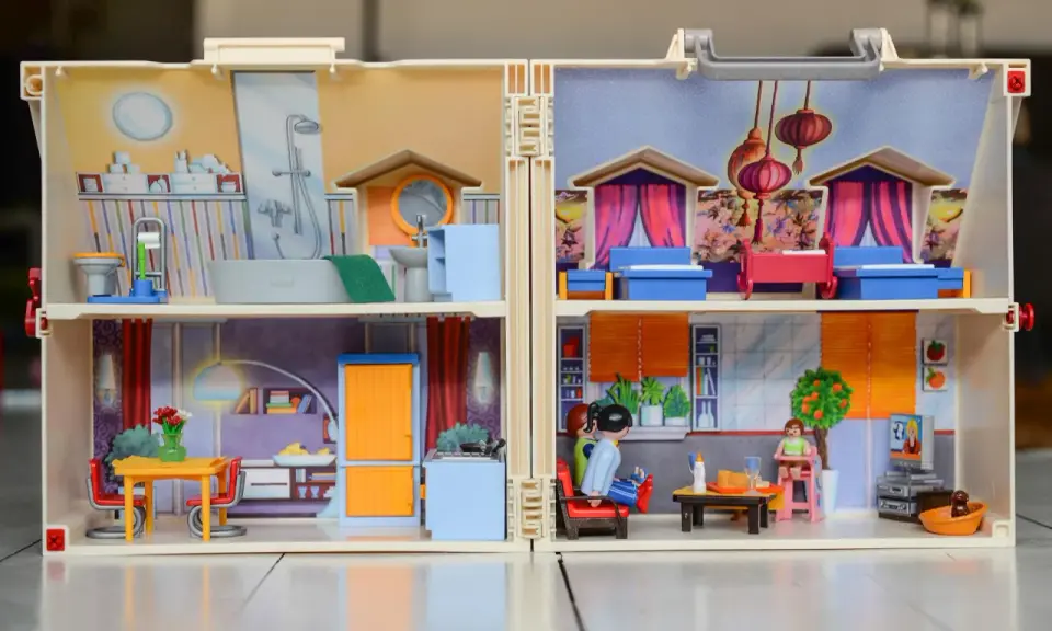 Casa de muñecas con habitaciones detalladas, mostrando actividades de la vida diaria ejemplos como baño, cocina y sala.