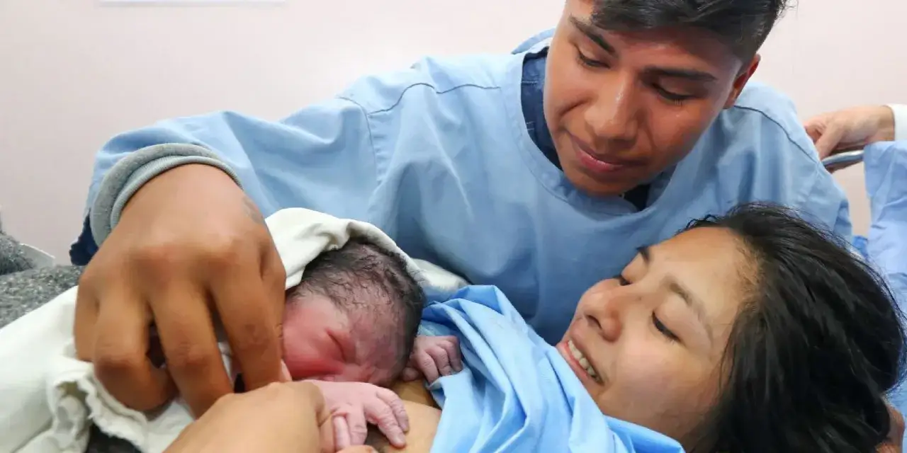 Un padre emocionado y una madre sonr&iacute;en mientras sostienen a su reci&eacute;n nacido. Piel con piel hasta cuando el amor los abrace.