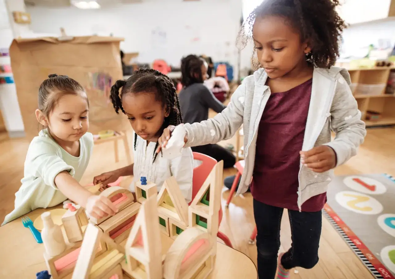 Ni&ntilde;as construyendo con bloques de madera, un ejemplo de pedagog&iacute;a del juego donde la creatividad y el aprendizaje se unen.