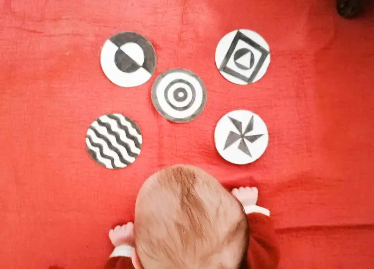 Beb&eacute; de 3 meses explorando tarjetas de alto contraste, ideales para cuentos de beb&eacute;s.