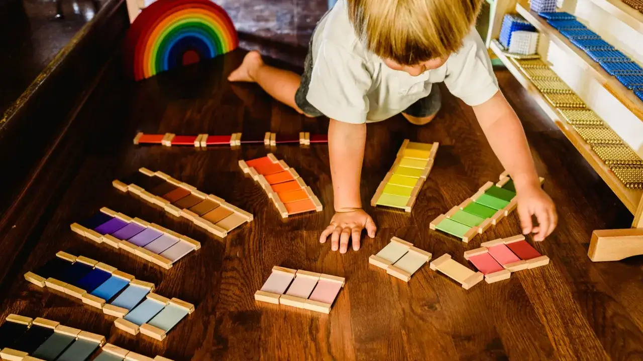 Ni&ntilde;o explora el periodo sensible del color con bloques de madera y arco&iacute;ris.